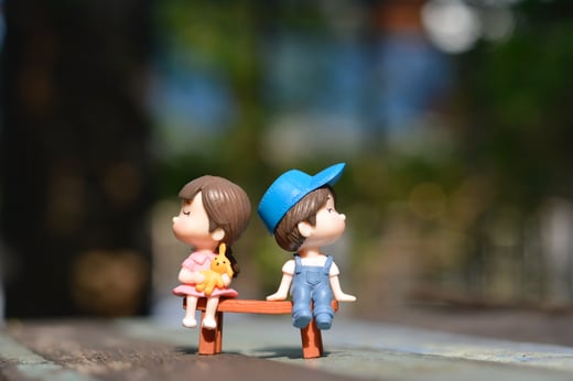 Boy and girl statues on bench