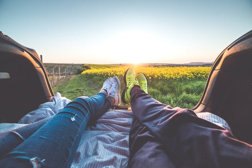 legs of two people lying in the back of a truck