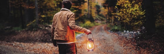 man-holding-a-lamp-in-the-woods