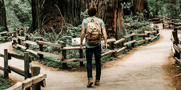 man standing at fork on path