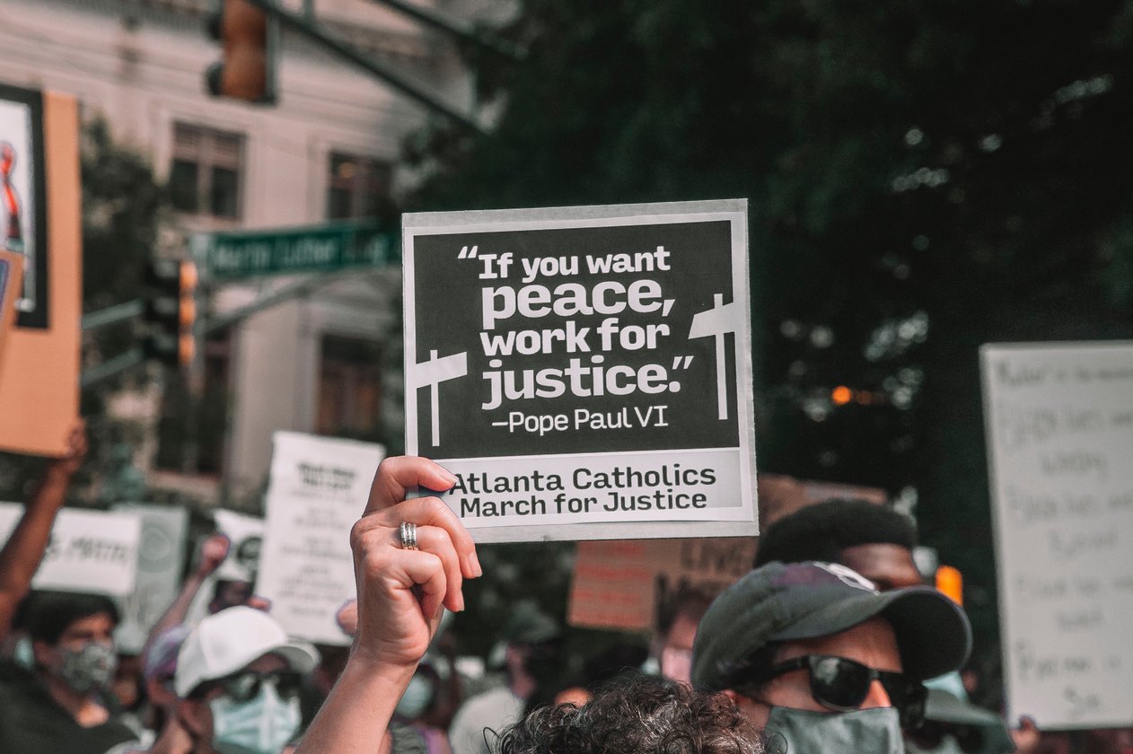 Sign being held up during a protest/Photo by maria-oswalt-gqb8jI9DEZU-unsplash