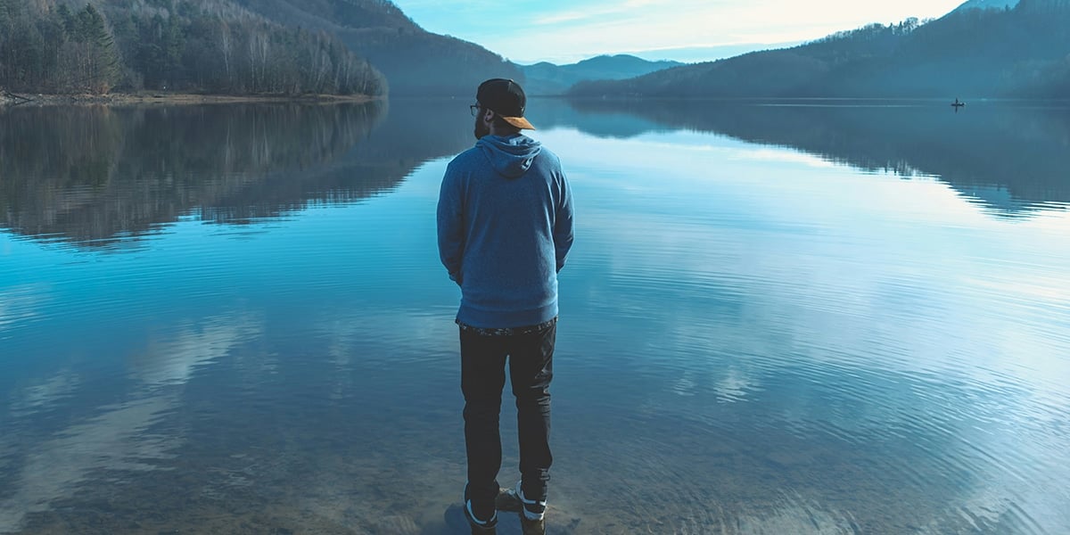 men_standing_lake