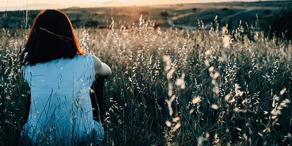 woman-sitting-in-field